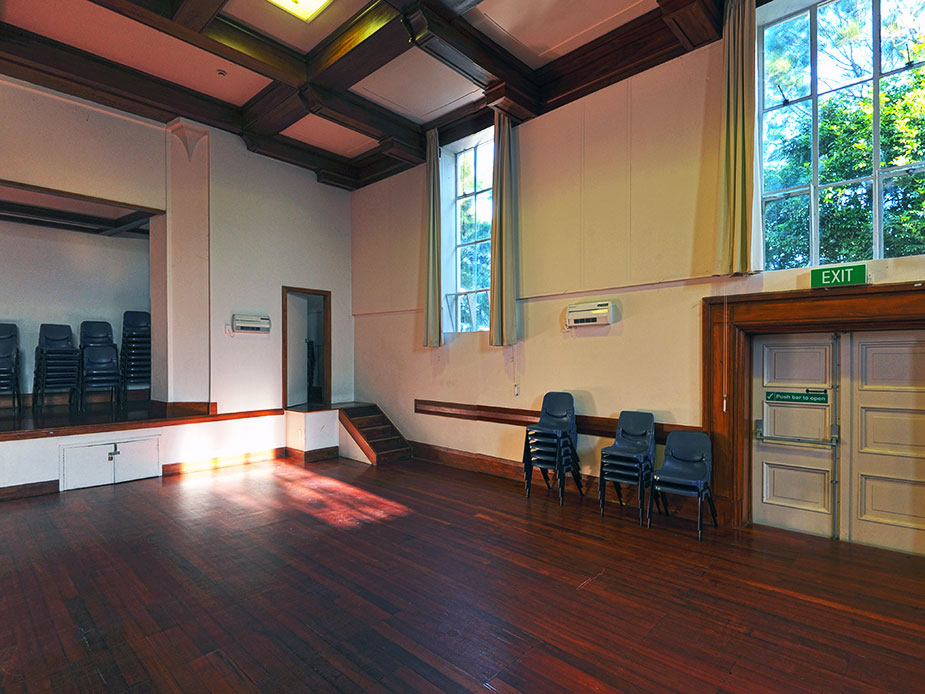 Heritage hall interior with timber floor, raised platform and tall windows