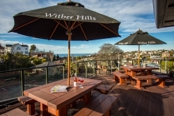 Rooftop deck with outdoor tables, umbrellas, and harbour views