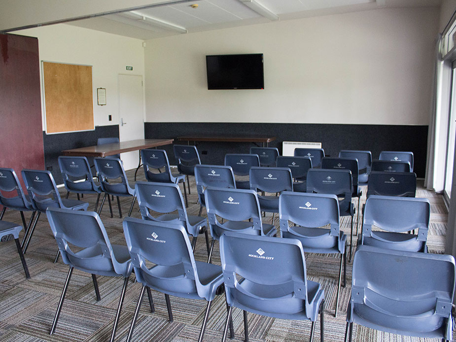 Meeting room with rows of chairs and a wall-mounted screen