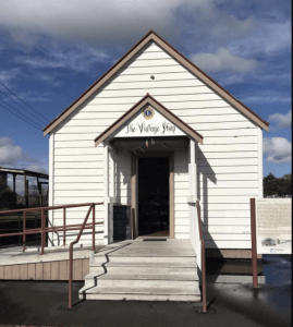 Small white weatherboard building with gable roof and entry steps