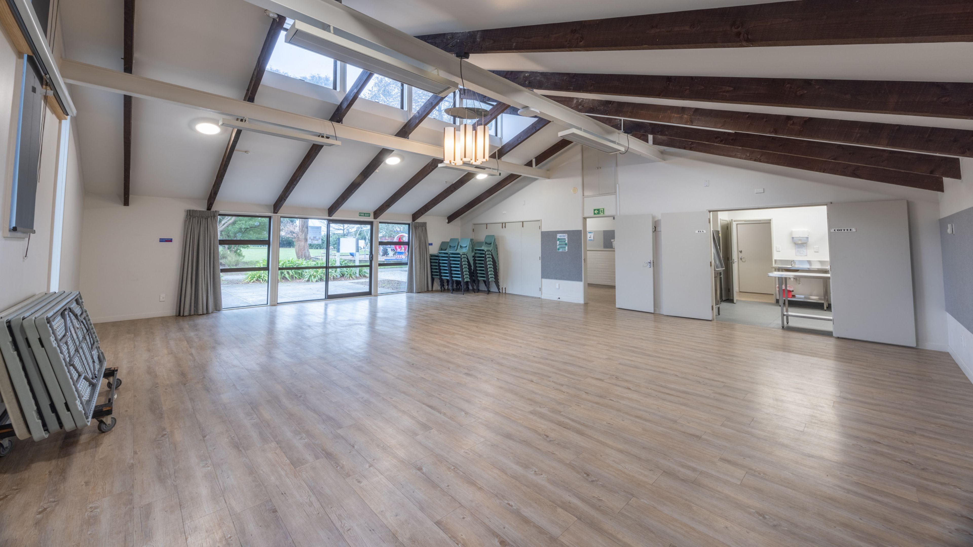 Community hall interior with exposed timber roof beams and timber floor