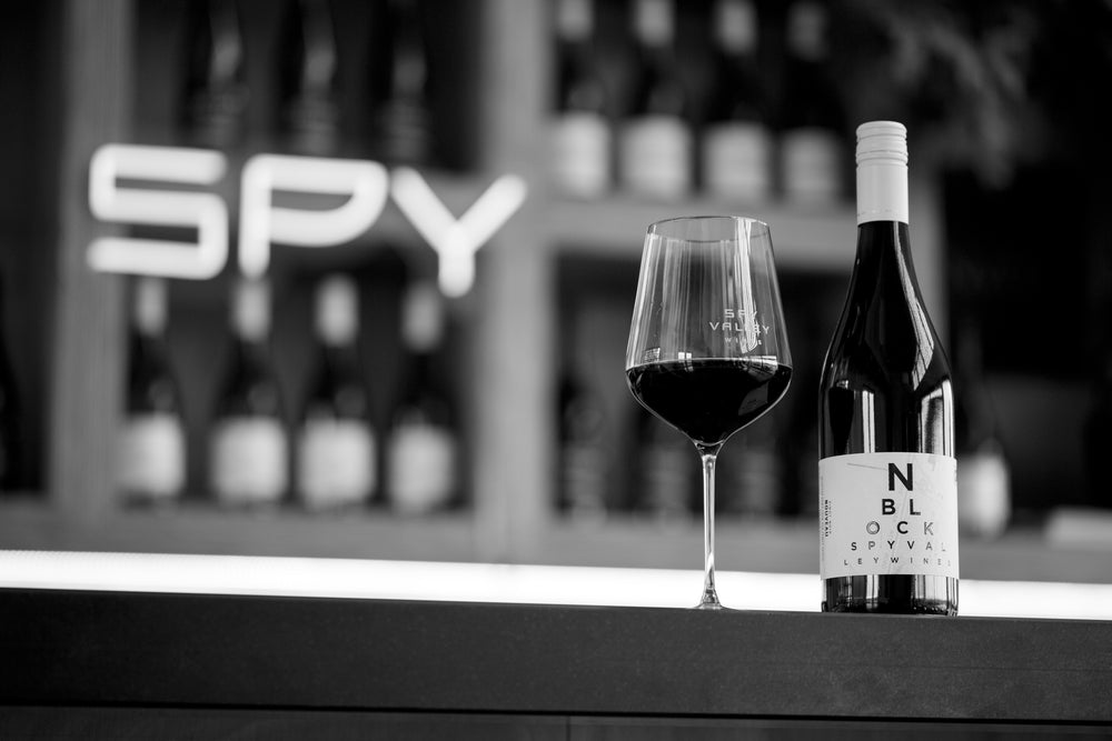 Wine glass and bottle on cellar door counter in black and white