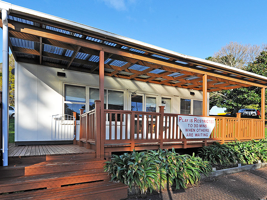 Single-storey pavilion with timber deck and corrugated roof canopy