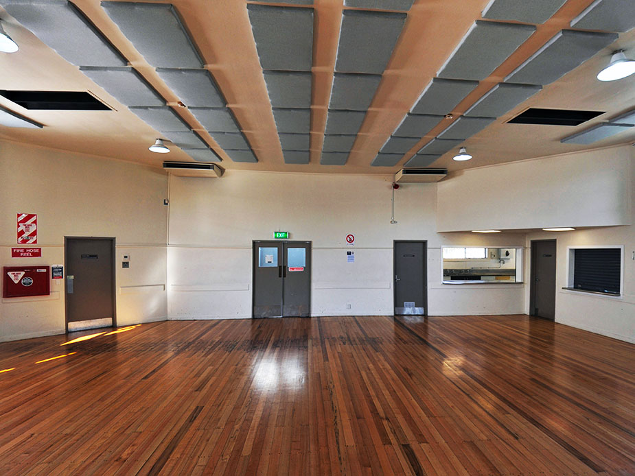 Open hall with polished timber floor and acoustic ceiling panels