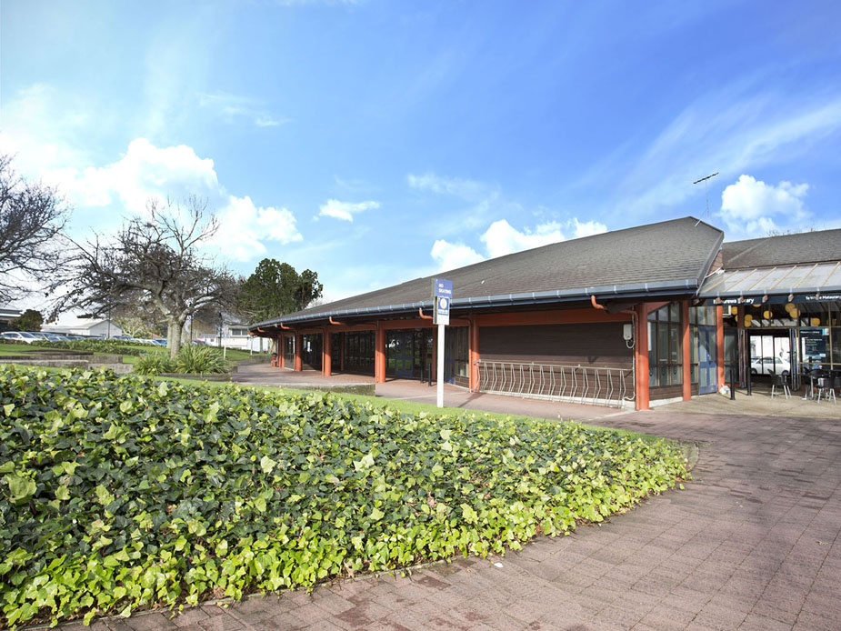 Single-storey library building with timber roof and hedge-lined frontage