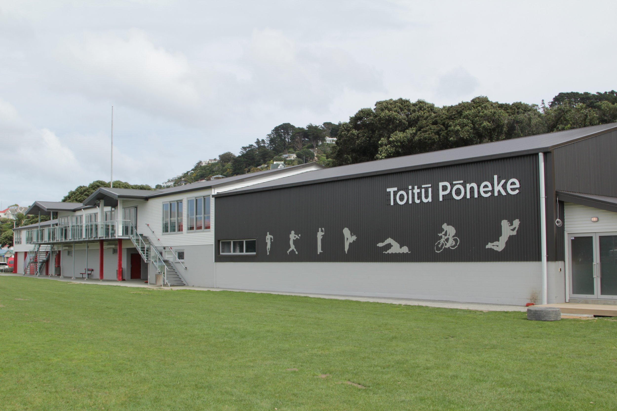 Large sports centre building with Toitu Poneke signage and sports silhouettes