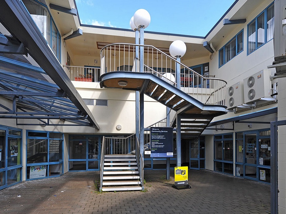 Courtyard with external staircase, upper-level balcony, and ground-level shopfronts