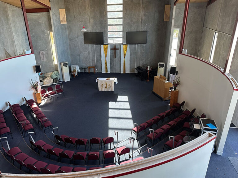 Church interior side wall showing large timber cross and concrete walls