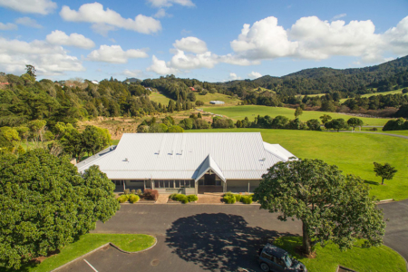 Aerial view of a large white-roofed event centre building set in rural farmland