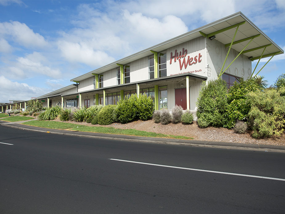 Two-storey community centre building with Hub West signage, green accents and landscaped frontage
