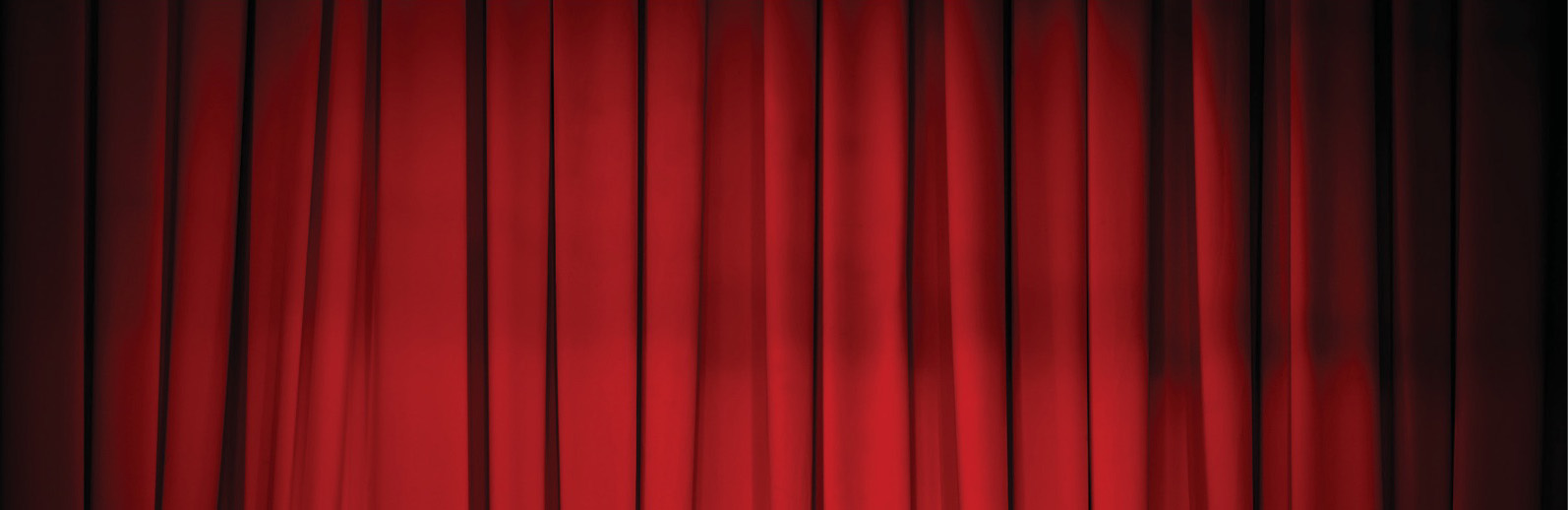Deep red theatre curtain under stage lighting, close-up