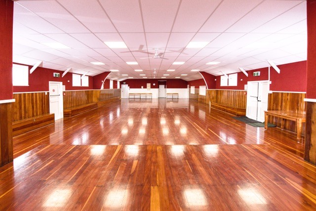 Large empty hall with polished red-brown timber floor, red painted walls, timber wainscoting