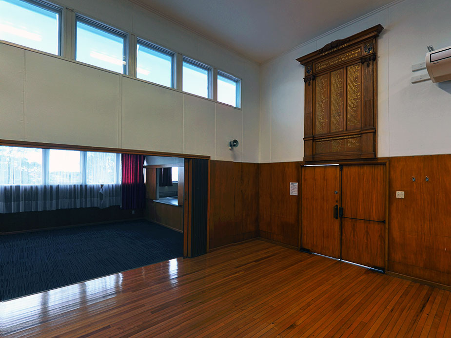 Hall interior with polished wood floors, timber wainscoting and a memorial honour board