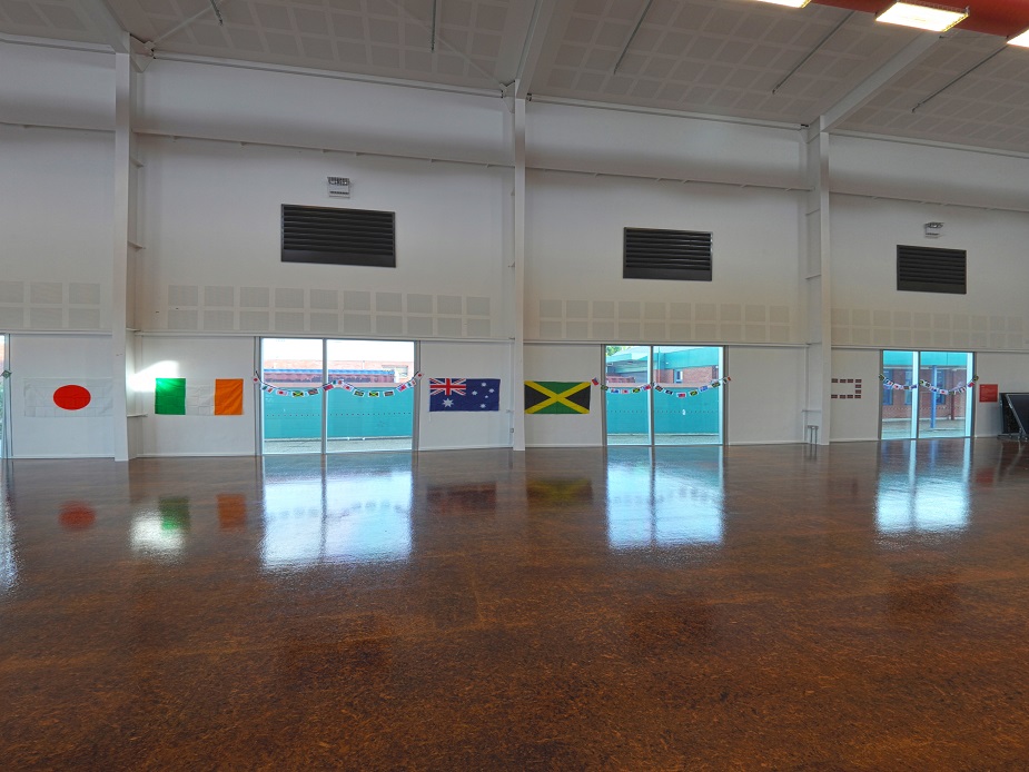 Large hall with polished floor, national flags displayed along glass wall panels