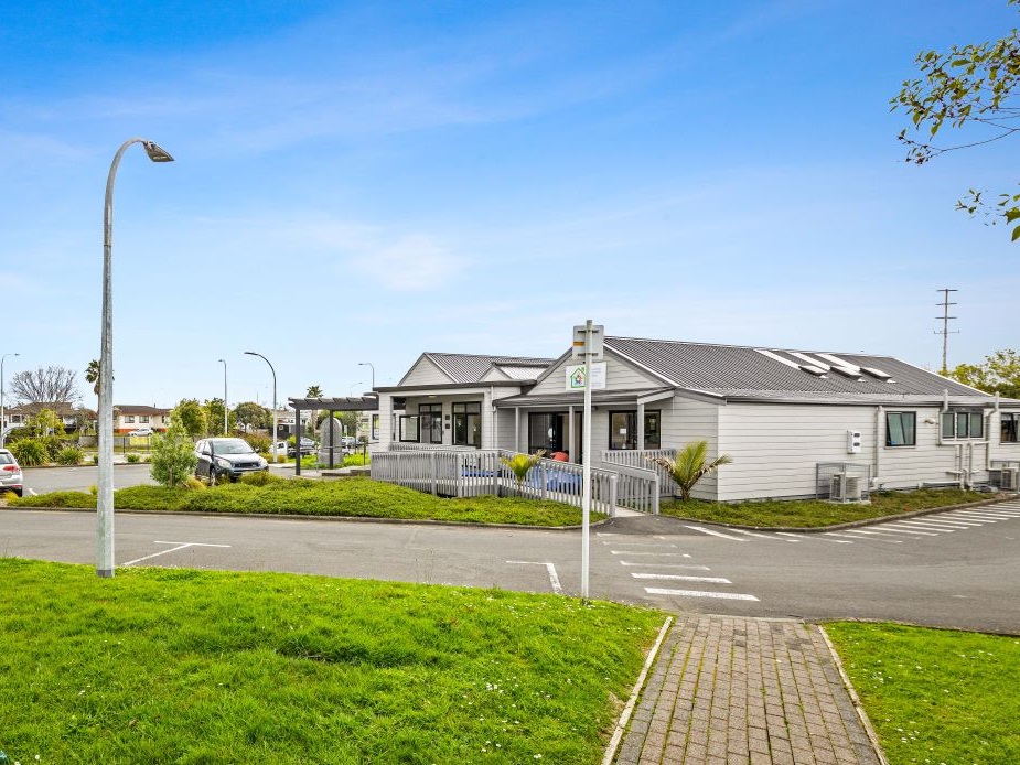 Single-storey community house building with car park and street lighting