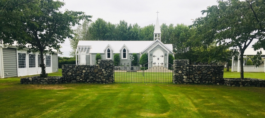 Chapel and garden with iron gates, stone walls and lawn