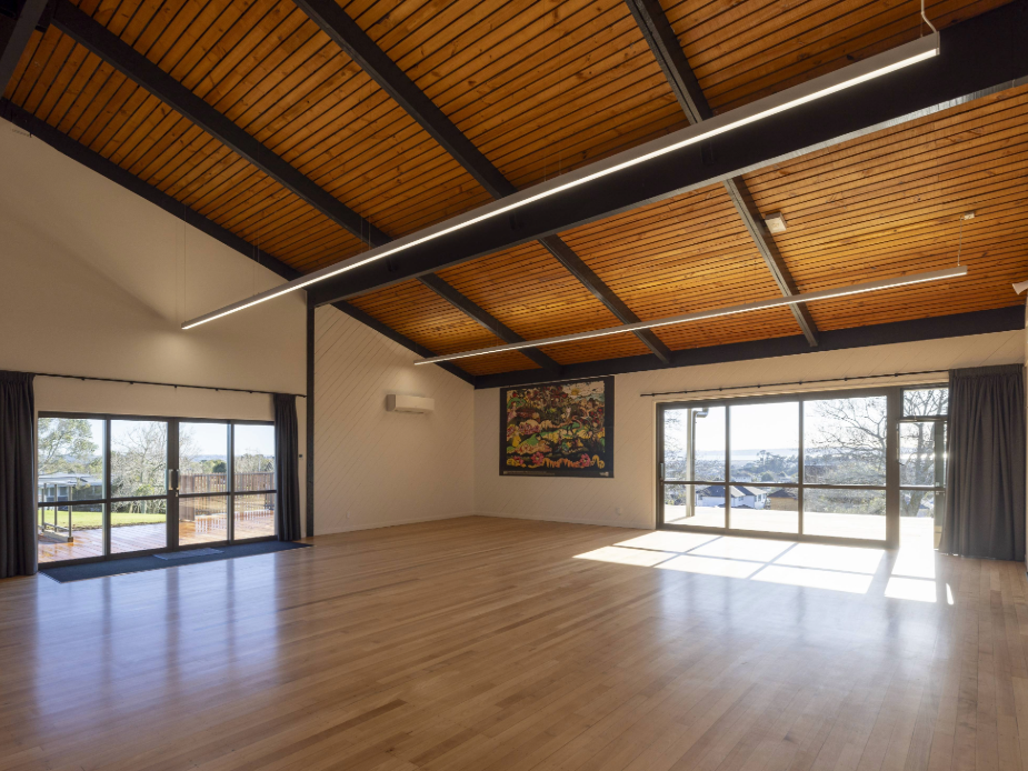Spacious hall with timber roof, artwork on wall and views through glazed doors