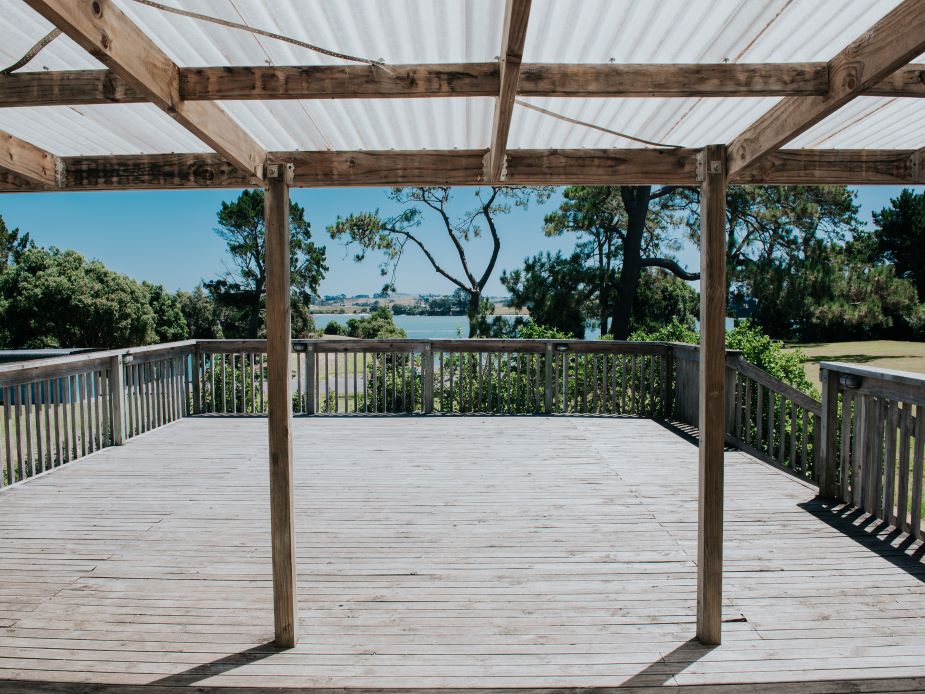 Timber deck with pergola structure overlooking water and trees