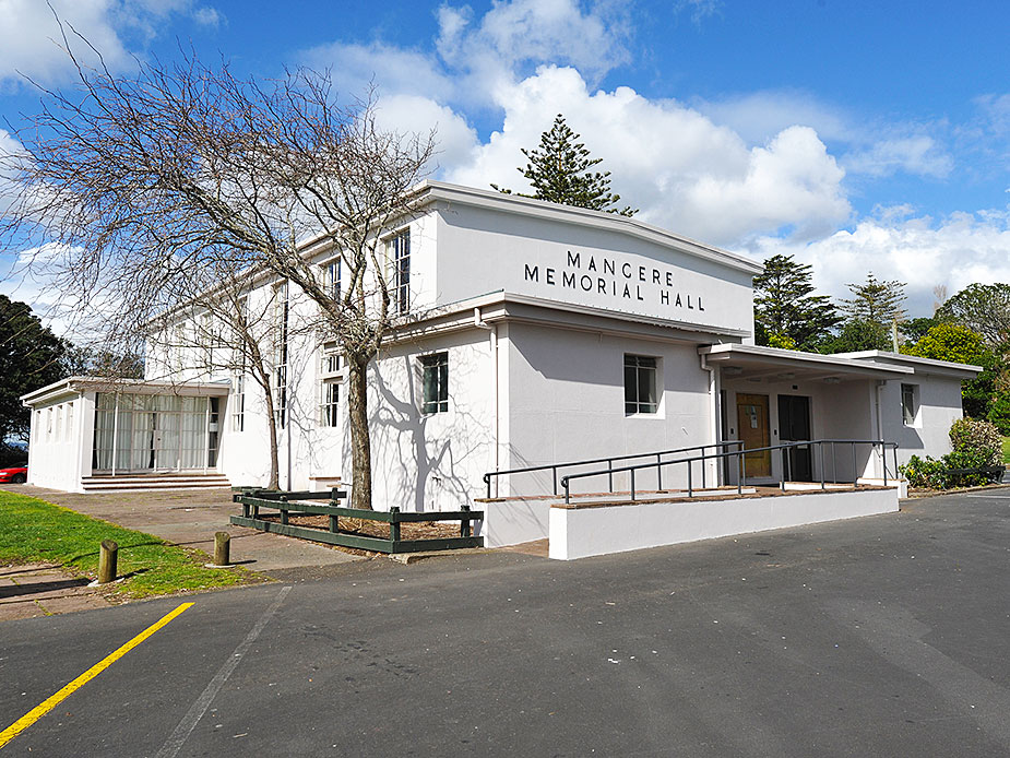 White rendered memorial hall with flat roof and name signage