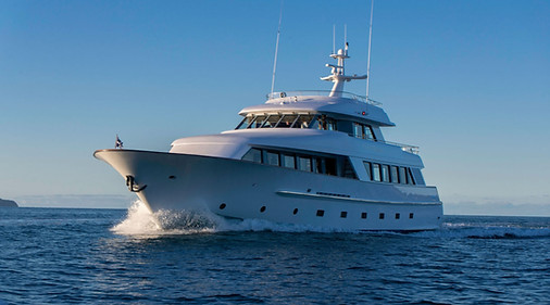 Motor yacht underway in calm blue water, bow-on view