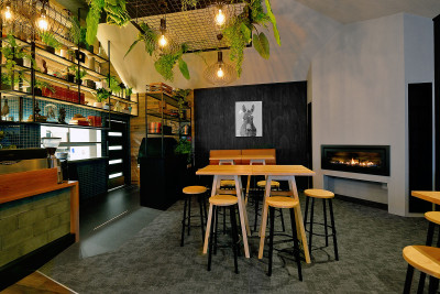 Bar area with pendant lights, hanging plants and timber bar top