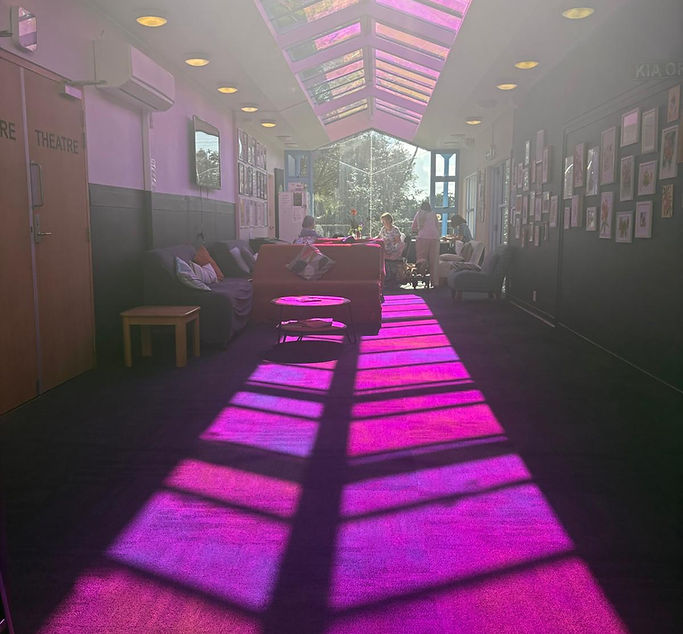 Long corridor interior with coloured light falling through skylight roof panels