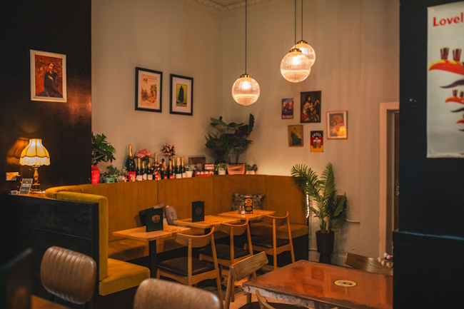 Intimate dining nook with warm pendant lights, booth seating and framed artwork