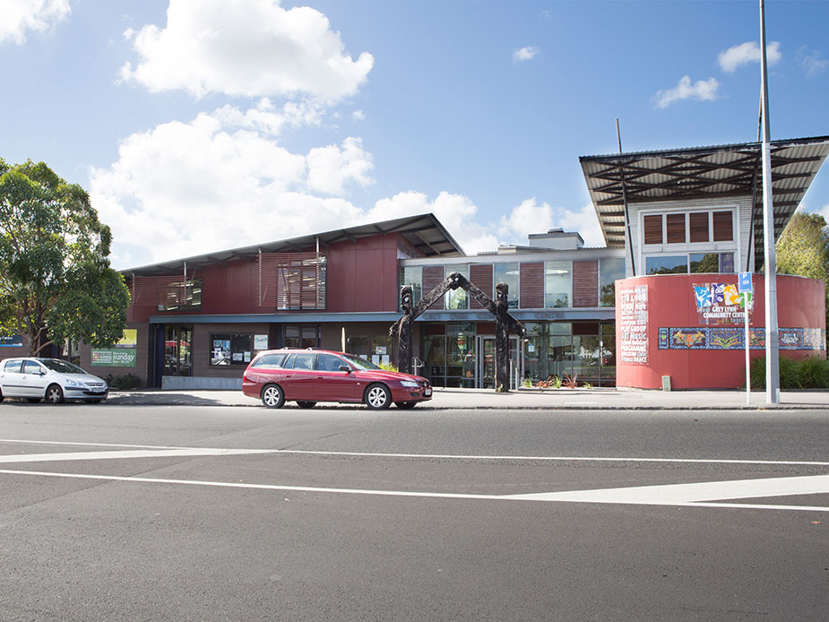 Contemporary community centre building with red cladding and street sculpture