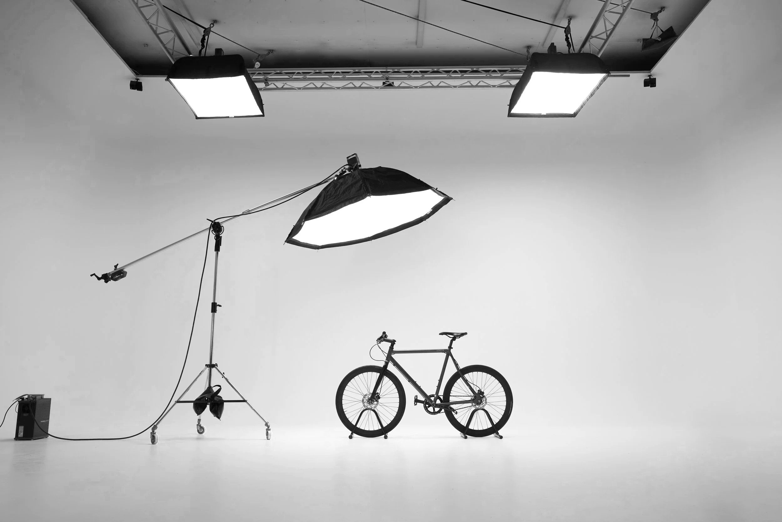 White cyclorama studio with lighting rigs and bicycle on seamless floor