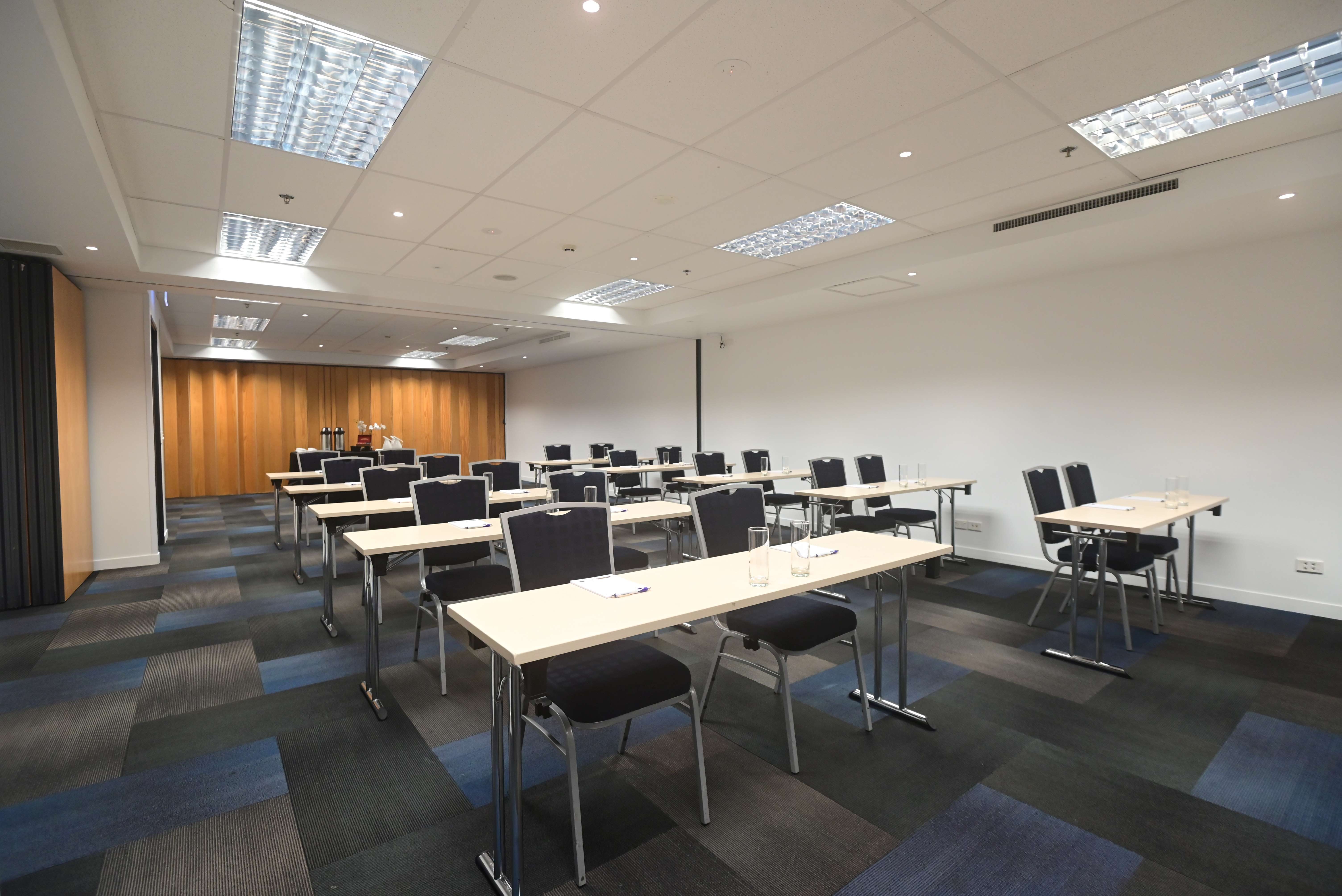 Meeting room with classroom table layout and stacked chairs
