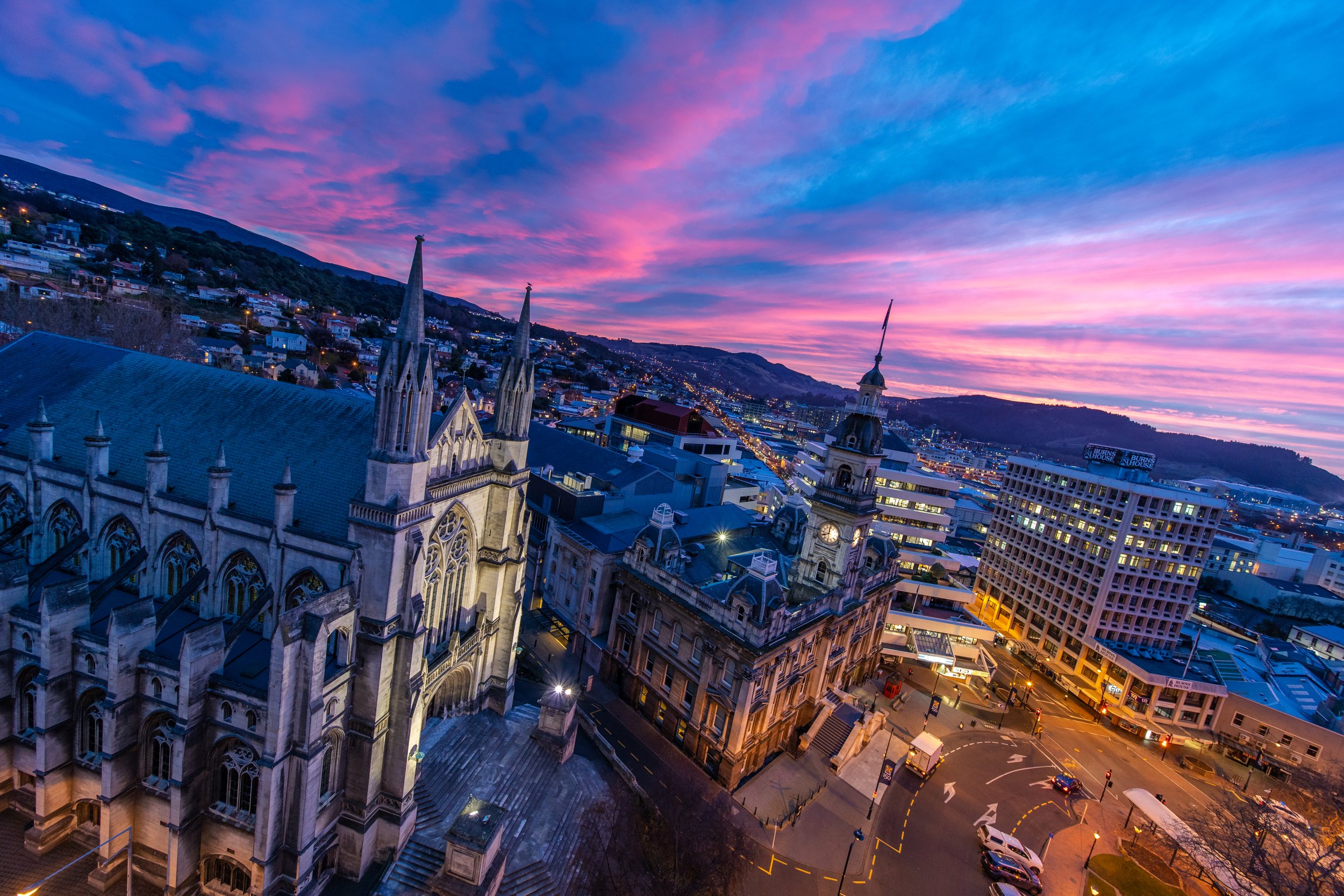Aerial view of a Gothic cathedral and city centre at dusk with colourful sky