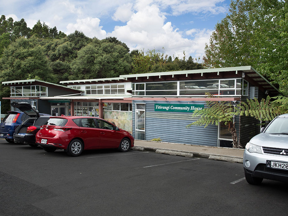 Low-rise community building with signage beside car park