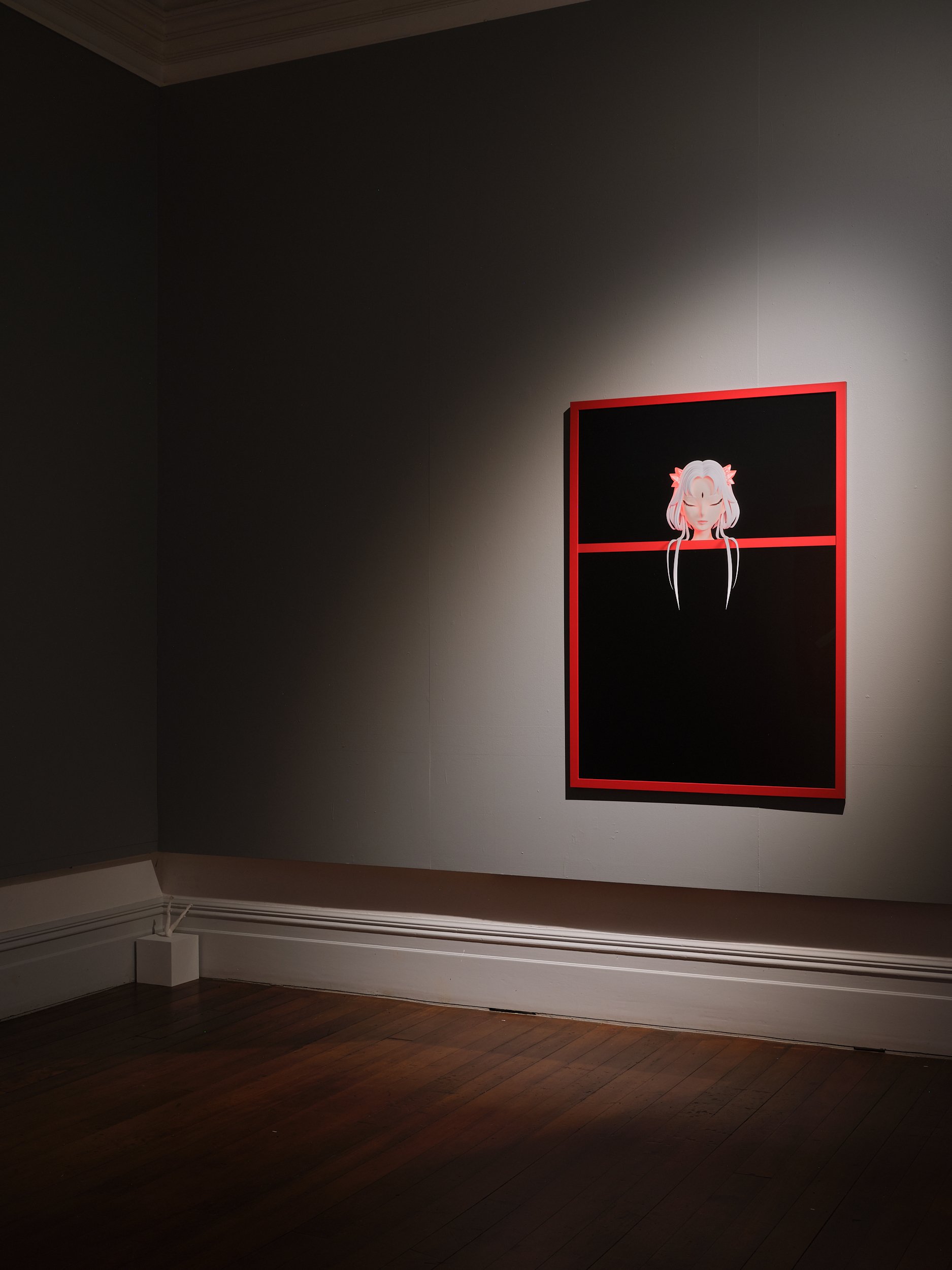 Dark-walled gallery room with single spotlit artwork in red frame, timber floor, ornate cornice