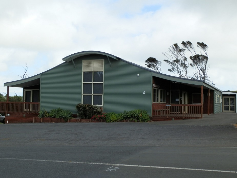 Green corrugated iron hall exterior with curved roof and verandah
