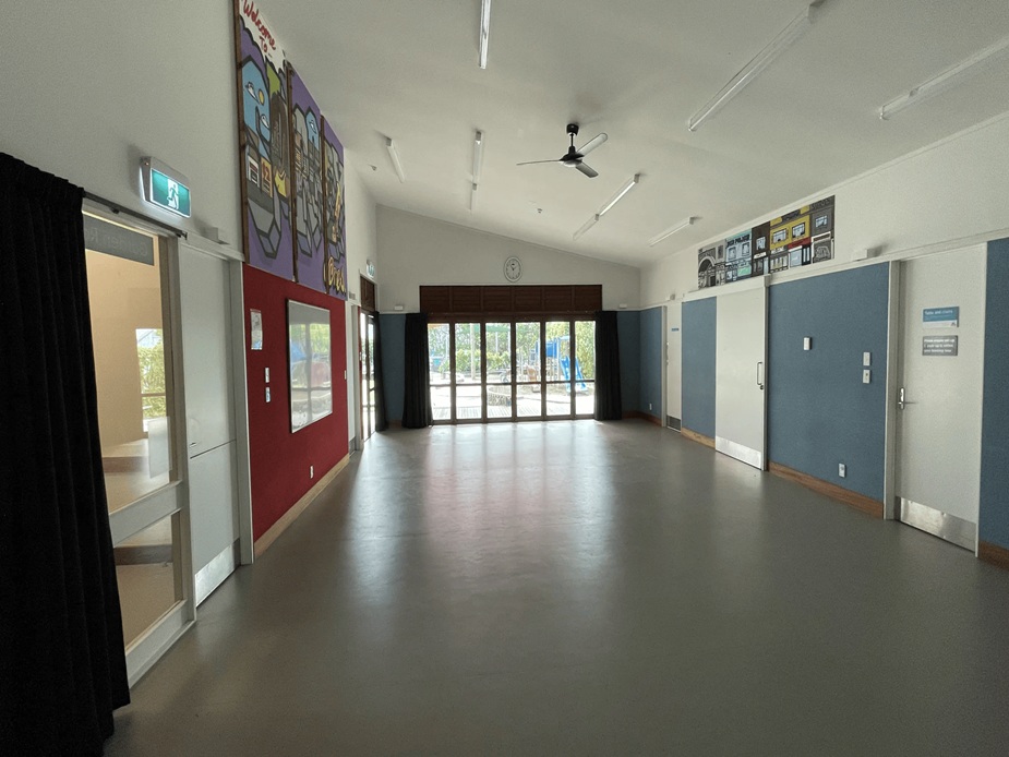 Plain rectangular hall with painted walls and double doors at far end