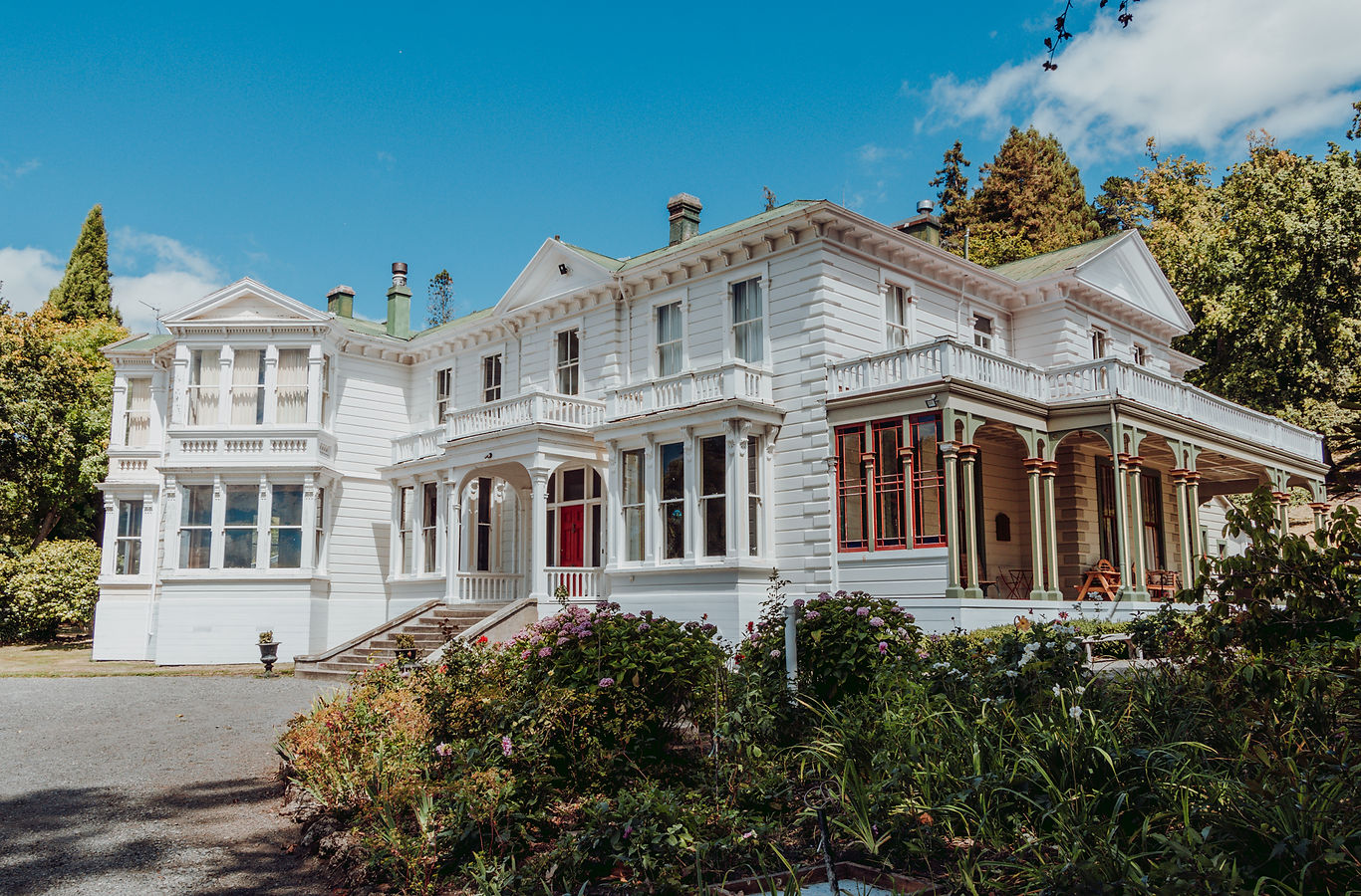 Large white Victorian-era homestead with verandahs, bay windows and ornate balustrades