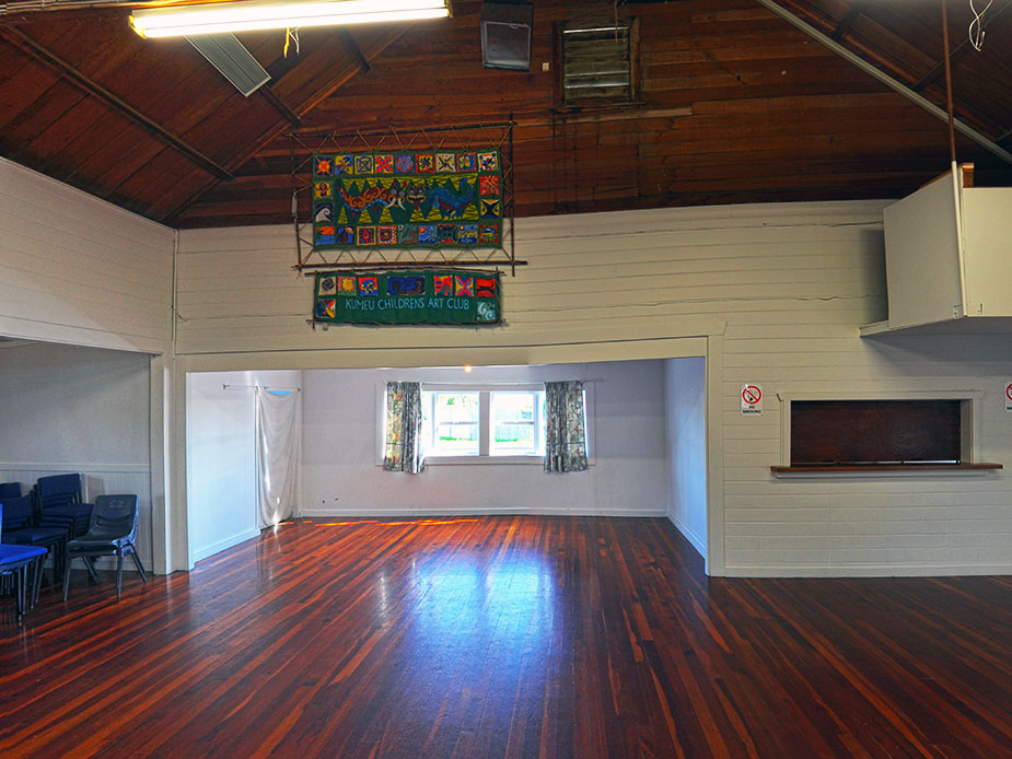Timber-ceilinged hall interior with polished wooden floor and colourful banner hanging on wall