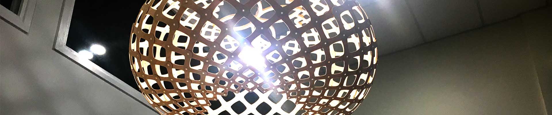 Close-up of a round woven pendant light fitting against a white ceiling