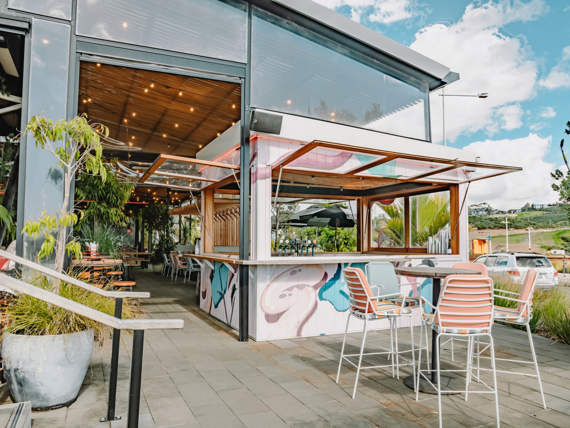 Outdoor bar and terrace area with colourful mural and seating