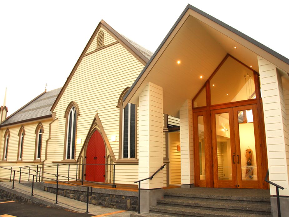 Heritage church exterior with red door and modern timber entrance addition