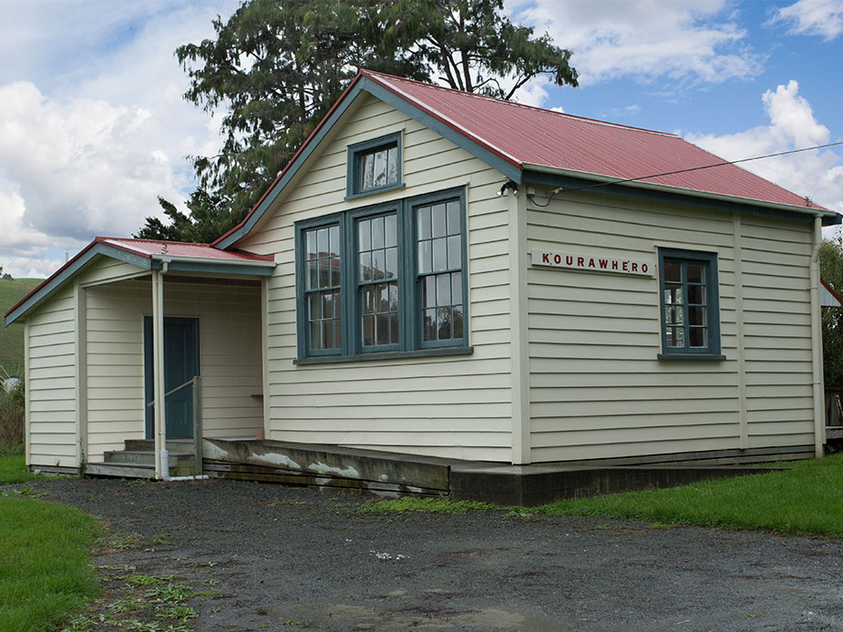Small weatherboard hall with red roof and covered entry porch