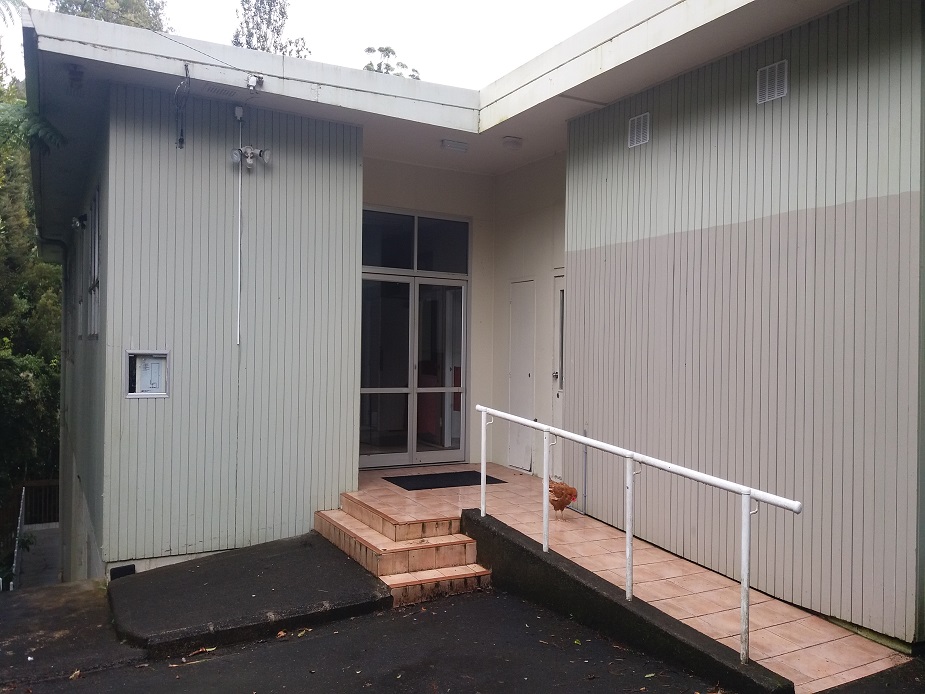 Close view of community hall entrance with ramp and vertical board cladding