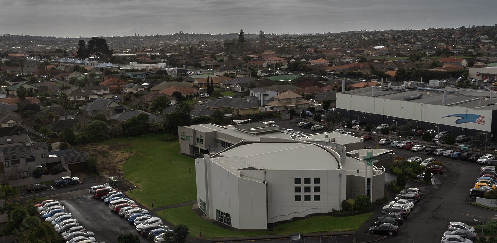 Aerial view of large church building with car parks in suburban setting
