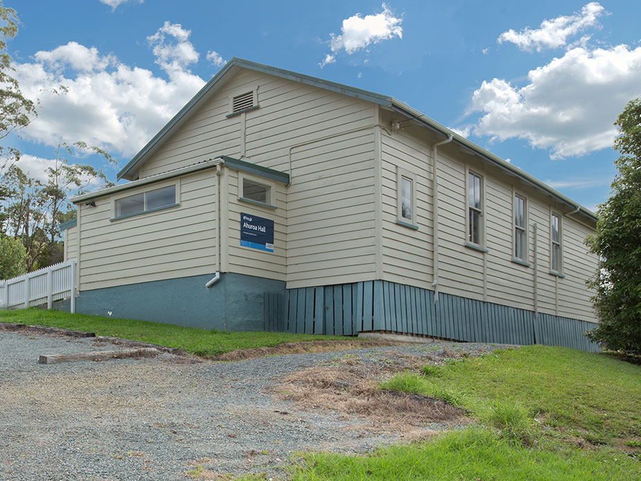 Weatherboard community hall exterior with signage and gravel car park