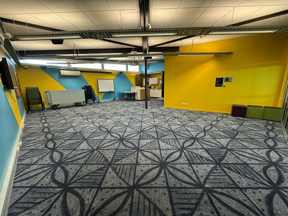 Empty room with yellow and blue painted walls and patterned carpet