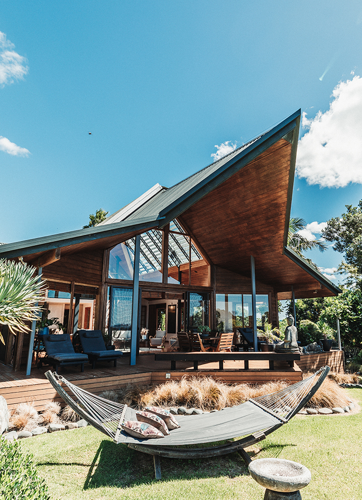 Lodge with distinctive angular timber roof, hammock and timber deck