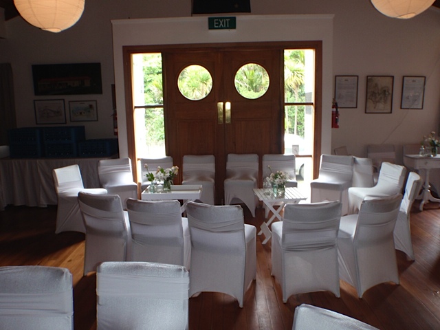 Hall set for a wedding with white chair covers and round porthole doors