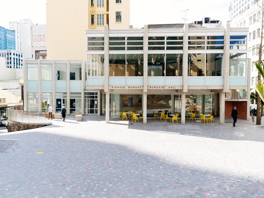 Glass-fronted Pioneer Womens Memorial Hall seen from across the plaza with pedestrians