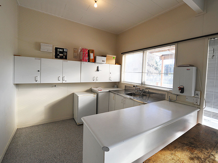 Plain kitchen with white cabinets, bench, and sink