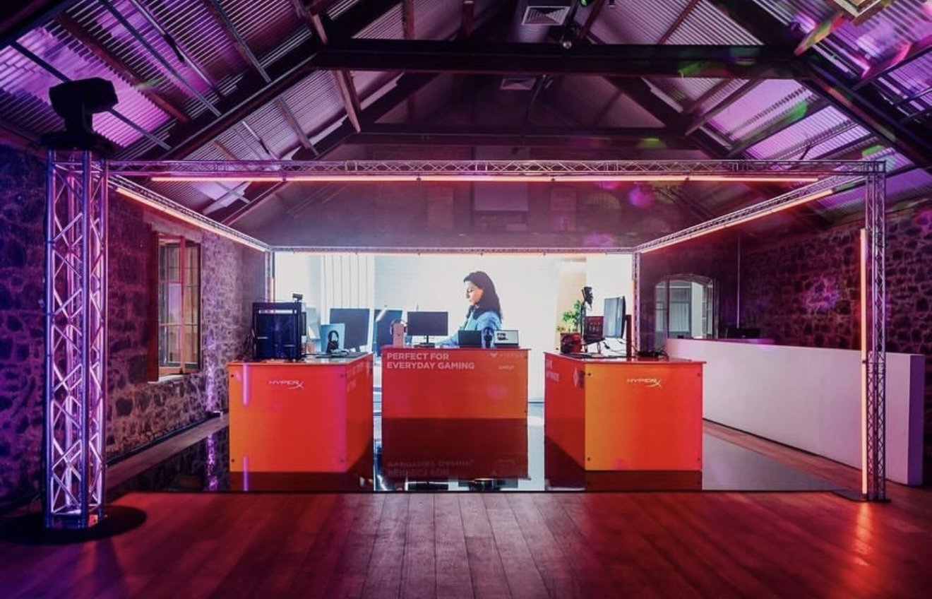 Stone-walled interior with exposed timber trusses and red uplighting, fitted with truss rigging and projector screen